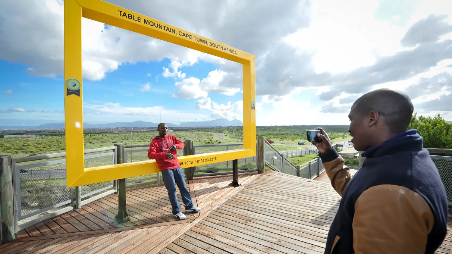 Khayelitsha residents Muzikayise Radebe poses for Mfesane Cwati at the Lookout Hill frame of Table Mountain in Khayelitsha